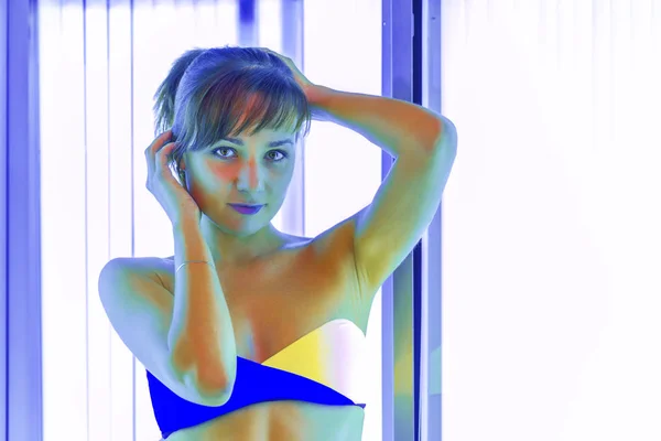 Sottile donna in solarium abbronzarsi — Foto Stock