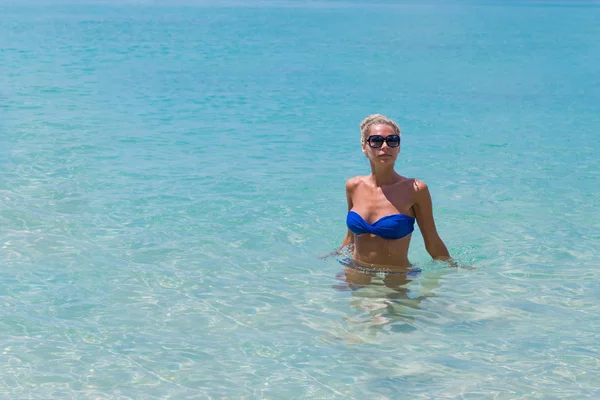 Mince femme blonde nageant sur la plage tropique — Photo
