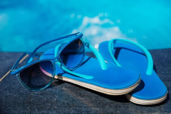 Hausschuhe und Sonnenbrille am Pool — Stockfoto