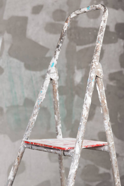 Old painted and stucco ladder on concrete wall