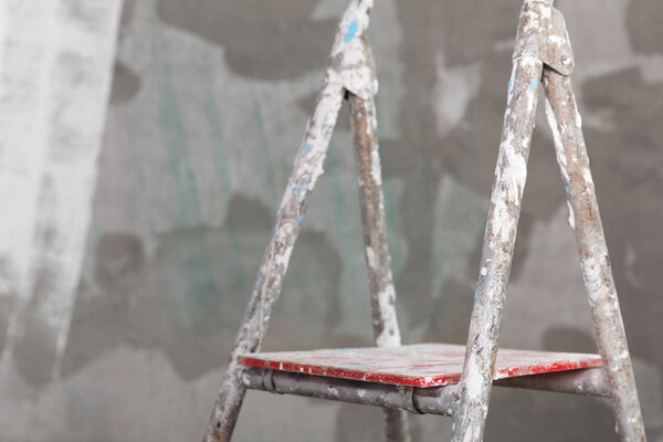 Old painted and stucco ladder on concrete wall