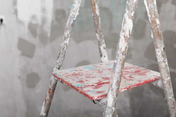 Old painted and stucco ladder on concrete wall