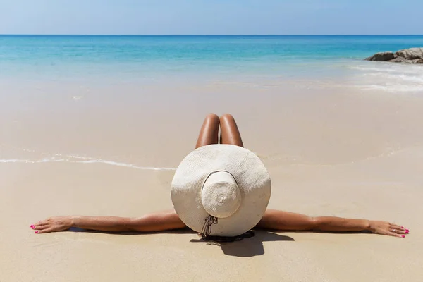 Schlanke brünette Frau mit Hut am Strand — Stockfoto