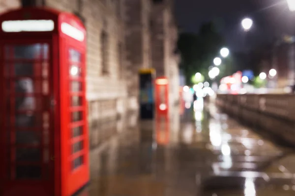 Cabina telefonica rossa in illuminazione notturna sfocata — Foto Stock