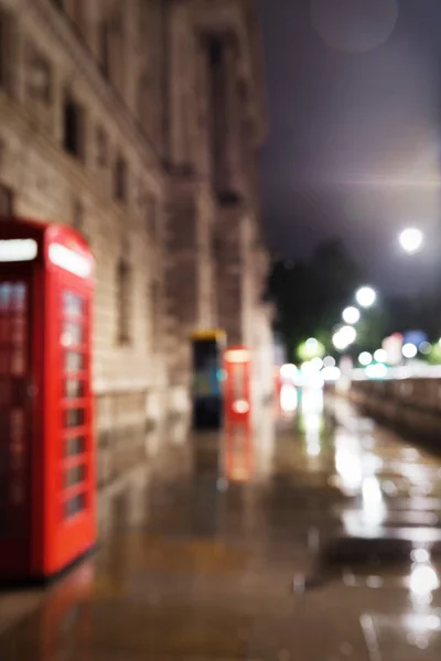 Červená telefonní budka v noci osvětlení rozostřený — Stock fotografie