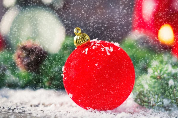 Röda julgranskulor med snö på trä — Stockfoto