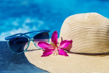 Çiçek ve hasır şapka ile güneş gözlüğü