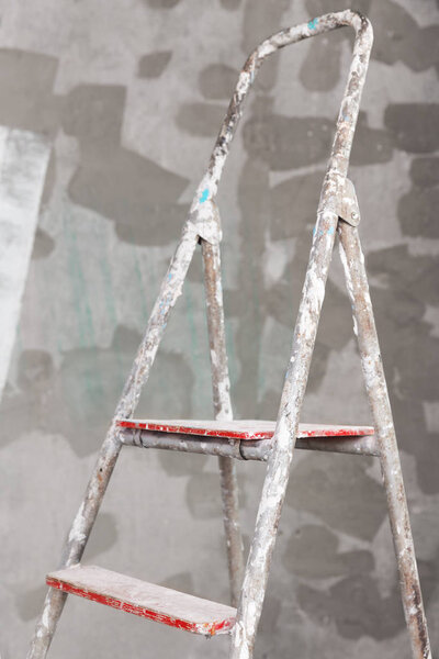 Old painted and stucco ladder on concrete wall