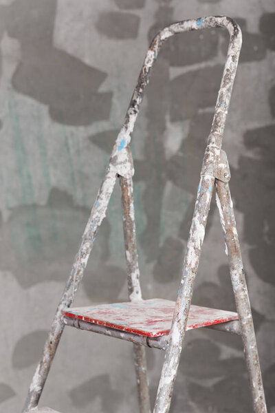 Old painted and stucco ladder on concrete wall