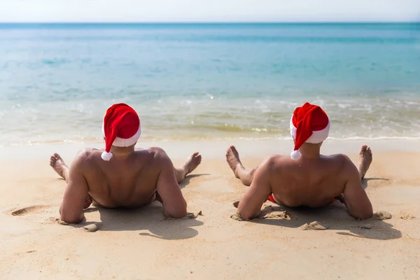 Uomo in Natale cappello rosso sulla spiaggia tropicale del mare — Foto Stock