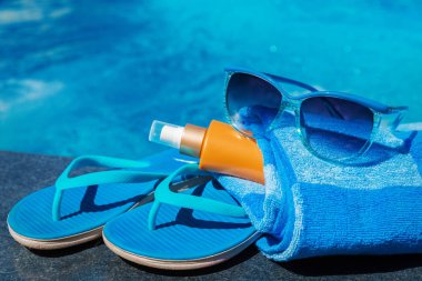 Güneş gözlüğü güneş koruyucu krem mavi terlik havlu