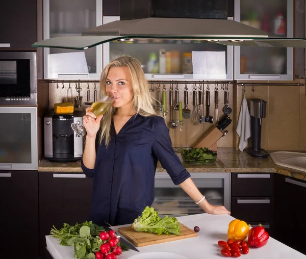 Blonde jeune femme cuisine salade dans la cuisine — Photo