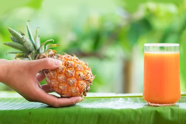 Exotické ananas džus žena ruku — Stock fotografie