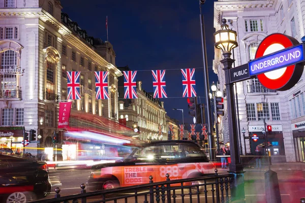 London, Anglia, Egyesült Királyság: 2017. június 16. - népszerű idegenforgalmi Picadilly circus zászlók Unió Jack az éjszakai fények megvilágítás — Stock Fotó