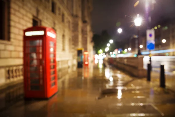 Blurry red phone booth at night unfocused — Stock Photo, Image