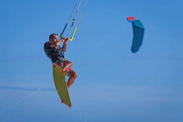 Jovem atlético montando kitesurf em um mar — Fotografia de Stock