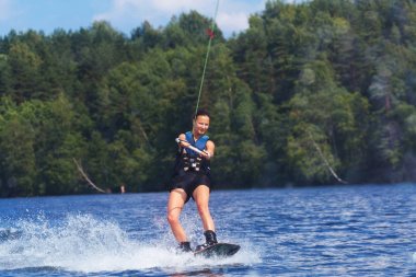 Genç oldukça ince esmer kadın mot dalga üzerinde wakeboard sürme