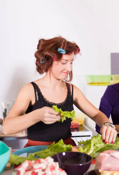年轻漂亮的女人家庭主妇烹饪用睫毛夹头发 — 图库照片