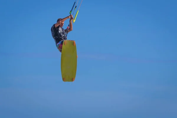 Giovane atletico cavalcare kite surf su un mare — Foto Stock