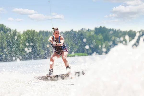 Jovem morena muito magro mulher montando wakeboard na onda de mot — Fotografia de Stock