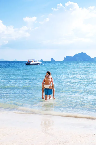 Feliz casal no amor namorado carregando sua namorada no mar em — Fotografia de Stock