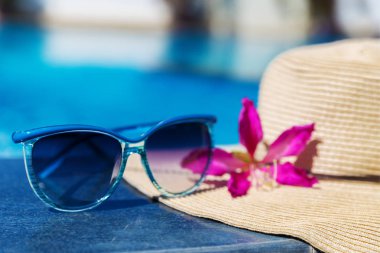 Yüzme kaka sınırında çiçek ve hasır şapka ile güneş gözlüğü