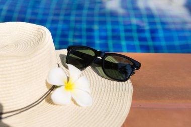 Yüzme kaka sınırında çiçek ve hasır şapka ile güneş gözlüğü