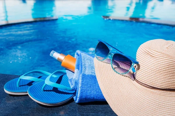 Blaue Hausschuhe mit Sonnencreme, Handtuch, Strohhut und Sonnenbrille — Stockfoto