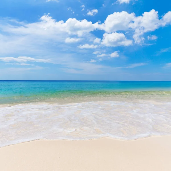 Slunečné tropické pláži s bílým pískem a modrá obloha — Stock fotografie
