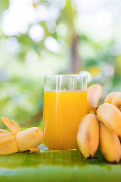 Bananenstrauß auf Blatt mit Smoothie-Saft-Drink im Glas — Stockfoto