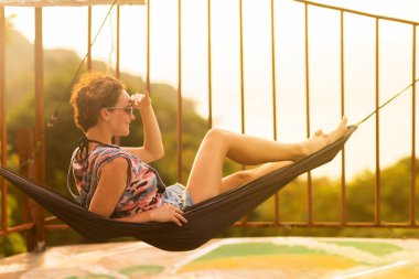 Tropikal egzotik hamakta genç ince kadın