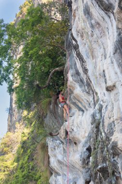 Genç ince atletik kadın üzerinde kaya tırmanışı