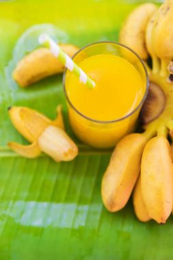 Salkım muzu cam suyu içkiyle yaprak üzerinde