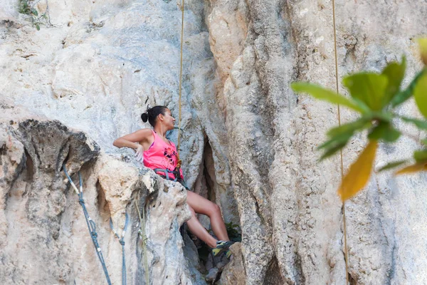 Young slim athletic woman climbing on rock — Stock Photo, Image