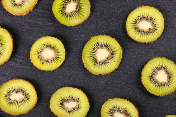 Kiwi frutas fatias no fundo ardósia preta . — Fotografia de Stock