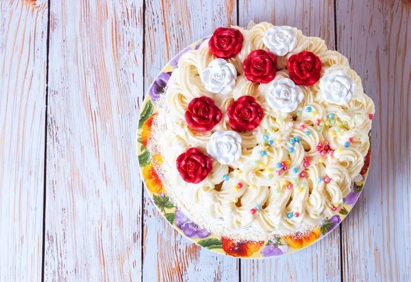 Белый торт со сливками и красными розами на белом блюде — стоковое фото