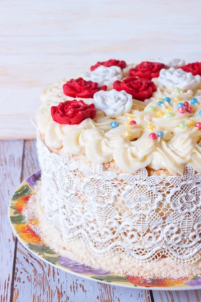 Белый торт со сливками и красными розами на белом блюде — стоковое фото