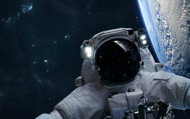 Dünya 'nın yörüngesindeki astronot yıldız kümelerinin arka planına karşı. Güneş Sistemi