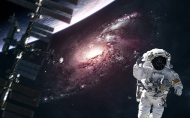 Uzayın derinliklerinde bir yerde kırmızı bir sarmal galaksi. Astronot, bulanık uzay istasyonu, gezegen