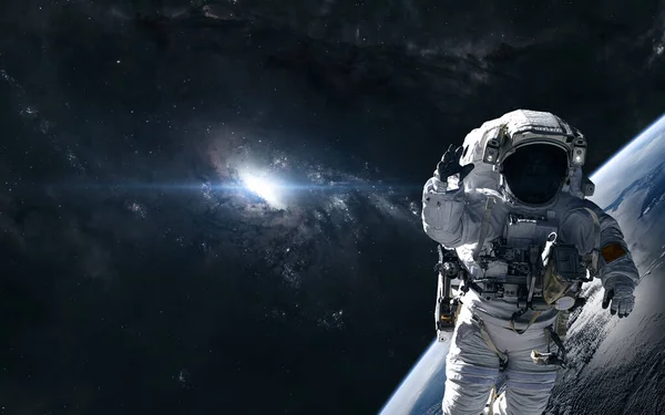 Astronaut på bakgrunden av en ljus stjärna i centrum av galaxen. Djup rymdplanet — Stockfoto