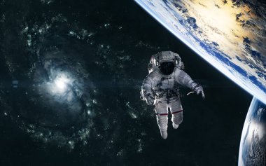 Astronot, sarmal galaksinin arka planındaki gezegenler uzayın derinliklerinde bir yerlerde.