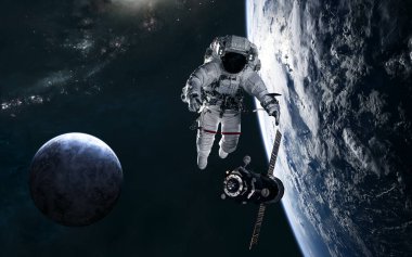 Astronot, uzay istasyonu, uzayın derinliklerindeki gezegenler sarmal galaksinin arka planına karşı.