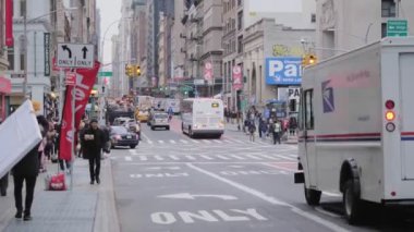 New York, Ocak 2020. İnsanlar kaldırımda yürürken, otobüsler ve taksiler trafikte yürürken Soho kavşağında beyaz minibüs duruyor.