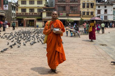 Tanımlanamayan keşiş bağış için ayakta duruyor ve Nepal 'deki ünlü Budist Tapınağı Boudhanath Stupa' da ilahiler söylüyor. Boudha Stupa dünyanın en büyük pagoda 'sı, dev Buda' nın gözleri 
