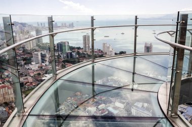 66. katta saydam cam zemin ve Malezya 'nın Penang Kulesi' nden Penang adasının havadan görüntüsü olan gökyüzü yürüyüşü. Komtar Penang, Georgetown 'un merkezinde 65 katlı bir gökdelendir.