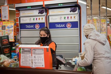 Yüzünde maskeyle süpermarkette kasiyer. Nisan 2020, Moskova.