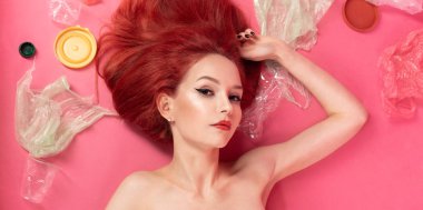 Kız plastik çöplerin arasında yatıyor. Psatik kirlilik sorunu