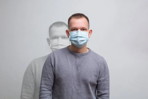 Hombre Con Una Máscara Médica Mira Cámara Sobre Fondo Neutro — Foto de Stock