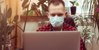 Bir dairede çalışan bir adam. Maske tak. Karantinaya alın. Pankart