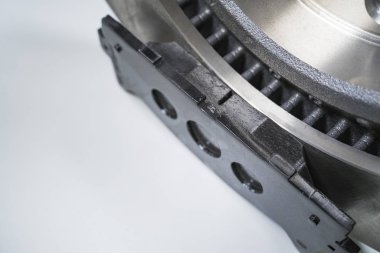 Beyaz bir masada fren yastıkları ve otomobil parçaları.